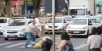 Motociclista e agente de trânsito são flagrados trocando socos no meio da rua em MG  Foto: Reprodução