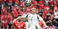  Foto: Angelos Tzortzinis/AFP via Getty Images - Legenda: Attila Szalai tenta controlar a bola para a Hungria. Ao fundo, NDoye obnserva opara a Suíça / Jogada10