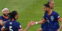  Foto: Christophe SIMON/ AFP via Getty Images - Legenda: Gakpo (à direita, camisa 11) comemora  o seu gol com Aké (5), que deu o passe para o companheiro marcar o primeiro gol da Holanda / Jogada10