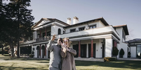 Adele e o marido posando com a mansão de fundo  Foto: Reprodução/Instagram/@adele