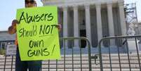 Homem segura carta contra posse de armas por condenados por violência doméstica em frente à Suprema Corte dos EUA  Foto: REUTERS/Amanda Andrade-Rhoades