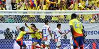  Colombianos comemoram o gol de Muñoz (centro, sendo celebrado pelos companheiros) o primeiro no duelo contra o Paraguai  –  Foto:   Aric Becker/ AFP via Getty Images / Jogada10