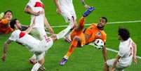 Atacante da Holanda, Gakpo (de laranja) disputa a bola com Çalhanoglu, da Turquia.  Foto: Ronny Hattmann/AFP via Getty Images / Jogada10