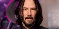 Imagem do rosto de Keanu Reeves, um homem branco, de barba, com o cabelo escuro e liso pouco acima do ombro Foto: Getty Images / BBC News Brasil