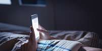 Se você está com dificuldade de largar o seu celular na hora de dormir, deixe ele fora do quarto  Foto: iStock / Jairo Bouer