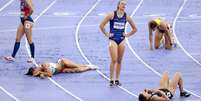 Atletas exaustas deitadas na pista após competir no heptatlo feminino nos Jogos Olímpicos de Paris 2024   Foto: Patrick Smith/Getty Images / BBC News Brasil