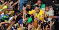 Bolsonaro chega a ato na Avenida Paulisa em fevereiro rodeado por apoiadores  Foto: Reuters / BBC News Brasil