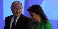 Vladimir Putin ao lado de Margarita Simonyan, editora-chefe da emissora estatal russa RT, que foi alvo de sanção dos EUA  Foto: Getty Images / BBC News Brasil