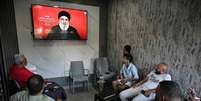 Refugiados palestinos ouvem um discurso do líder do Hezbollah, Hassan Nasrallah, em um café na entrada do campo de Sabra, em Beirute. Joseph Eid/AFP via Getty Images  Foto: The Conversation