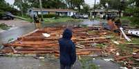 Um homem olha para um telhado na rua de uma casa próxima depois que um tornado atingiu a área enquanto o furacão Milton se aproximava de Fort Myers, Flórida, EUA, em 9 de outubro de 2024.  Foto: REUTERS/Ricardo Arduengo