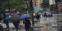 Com a chegada de uma frente fria em São Paulo, pedestres correm e se protegem da chuva repentina e do frio que faz nesta tarde de eleições municipais na Avenida Paulista, região centro-sul da capital paulista, neste domingo (27)  Foto: RENATO S. CERQUEIRA/ATO PRESS/ESTADÃO CONTEÚDO