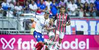  Foto: Rafael Rodrigues/EC Bahia - Legenda: Lucho Rodríguez do Bahia, recebe a marcação do são-paulino Marcos Antônio, Ao fundo, Luiz Gustavo observa / Jogada10