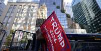 Uma pessoa segura uma bandeira em apoio a Donald Trump do lado de fora da Trump Tower, após a eleição de Donald Trump para presidente dos Estados Unidos, em Nova York. (6/11/2024)  Foto: REUTERS/Kent J. Edwards