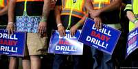 "Perfure, baby, perfure!": apoiadores seguram cartazes com frase de Trump em apoio aos combustíveis fósseis, que são o principal motor do colapso climático Foto: DW / Deutsche Welle