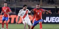  Foto: Daniel Apuy/Getty Images - Legenda: Vidal, do Chile (de vermelho) chega junto na marcação ao peruano Peña / Jogada10