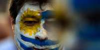 Homem com o rosto pintado com a bandeira do Uruguai   Foto: Getty Images / BBC News Brasil