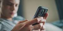 Stock image of a boy looking at a phone  Foto: Getty Images / BBC News Brasil