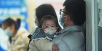 Um bebê acompanhado pelos pais, aguarda consulta com um médico no departamento de pediatria de um hospital em Hangzhou, na China, em 6 de janeiro de 2025 Foto: Getty Images / BBC News Brasil