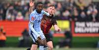  Foto: Michael Regan/Getty Images - Legenda: Pape Sarr, do Tottenham (de azul), luta pela bola com Dan Creaney, do Tamworth, em jogo pela Copa da Inglaterra / Jogada10