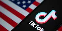 Um celular com logo do aplicativo do TikTok aberto em cima de uma bandeira dos EUA  Foto: Getty Images / BBC News Brasil