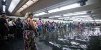 Passageiros enfrentam túnel alagado na Estação Jardim São Paulo-Ayrton Senna do Metrô (Linha 1-Azul), na zona norte da capital paulista, após o temporal que atingiu a cidade na tarde desta sexta-feira, 24.  Foto: AGATHA GAMEIRO/ZIMEL PRESS/ESTADÃO CONTEÚDO