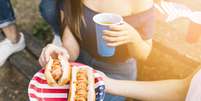 Amigos comendo cachorro-quente  Foto: Freepik