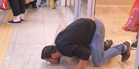 Brasileiro beija o chão do Aeroporto de Belo Horizonte ao chegar dos EUA  Foto: Reprodução/GloboNews