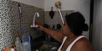 Dayana da Silva, 38, mostra que está sem água em casa em meio a uma onda de calor extremo na favela do Jacarezinho, no Rio de Janeiro, Brasil, em 18 de fevereiro de 2025.  Foto: REUTERS/Aline Massuca
