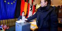 Eleitora alem&atilde; vota neste domingo, em Berlim  Foto: REUTERS/Fabrizio Bensch / BBC News Brasil