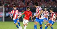  Foto: Carlos Parra/FFCh - Legenda: Jogadores de Paraguai e Chile em disputa de bola no Defensores del Chaco, em Assunção / Jogada10