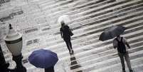 Pedestres se protegem da chuva na região central de São Paulo, na tarde de 31 de março  Foto: CRIS FAGA/DRAGONFLY PRESS/ESTADÃO CONTEÚDO