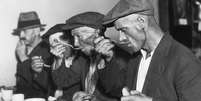 Homens comendo em 'soup kitchen' durante a Grande Depress&atilde;o nos EUA  Foto: Getty Images / BBC News Brasil