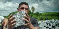 Trabalhador mostra pedra cortada em uma pedreira em Caiçara, interior da Paraíba; para Ministério do Trabalho e Emprego, ele estava sob condição análoga à escravidão  Foto: Vitor Serrano/BBC News Brasil / BBC News Brasil