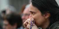 A emoção dos fiéis durante a primeira missa pública após a morte do papa, na Praça de São Pedro, no Vaticano, em 21 de abril de 2025.  Foto: AFP - ANDREAS SOLARO / RFI