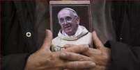 Um fiel argentino segura um retrato do papa Francisco entre as mãos, após o anúncio de sua morte, na segunda-feira, 21 de abril de 2025.  Foto: © AP - Gustavo Garello / archive RFI / RFI