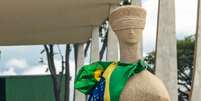 Est&aacute;tua do STF foi um dos monumentos depredados por manifestantes durante o dia 8 de janeiro. Ap&oacute;s limpeza, o monumento n&atilde;o apresenta mais a picha&ccedil;&atilde;o  Foto: Jo&eacute;dson Alves/Ag&ecirc;ncia Brasil / BBC News Brasil