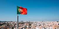 Imagem de Lisboa com bandeira de Portugal a frente Foto: Getty Images / BBC News Brasil
