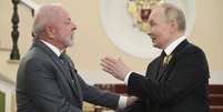 O presidente russo, Vladimir Putin (dir.), cumprimenta o presidente brasileiro, Luiz Inácio Lula da Silva, antes do desfile militar do Dia da Vitória em Moscou, em 9 de maio de 2025. O evento marca o 80º aniversário da vitória da União Soviética sobre a Alemanha nazista durante a Segunda Guerra Mundial.  Foto: © AP - Alexei NikolskyAlexey Nikolsky / Sputnik, Kremlin Pool Photo via AP / RFI