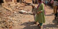 Mulheres caminham em dire&ccedil;&atilde;o &agrave; casa destru&iacute;da, ap&oacute;s a opera&ccedil;&atilde;o militar do Paquist&atilde;o contra a &Iacute;ndia, em Rehari, Jammu, em 10 de maio de 2025.  Foto: REUTERS - Adnan Abidi / RFI