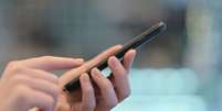 Mulher segurando smartphone  Foto: iStock