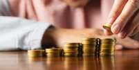 Quer atrair dinheiro com um ritual fácil? Veja como fazer a simpatia com moedas douradas para ativar a prosperidade no seu lar.  Foto: Shutterstock, / João Bidu