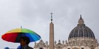 Imagem ilustrativa de homem com guarda-chuva com as cores do arco-íris em frente ao Vaticano  Foto: NurPhoto /GettyImages
