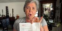 Vivian Hernández, que vive em Li'l Abner há 17 anos, mostra a ordem de despejo que recebeu Foto: BBC News Brasil