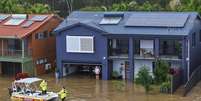 Equipes de resgate ajudam uma moradora ilhada pelas enchentes em sua casa em Port Macquarie, ao norte de Sydney, Austrália  Foto: AP - Lindsay Moller / RFI