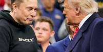 FILE PHOTO: Tesla CEO Elon Musk greets U.S. President Donald Trump as they attend the NCAA men's wrestling championships in Philadelphia, Pennsylvania, U.S., March 22, 2025. REUTERS/Nathan Howard/File Photo  Foto: Reuters