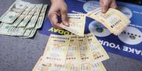 Lojista conta cartelas de apostas da Powerball  Foto: Jay L. Clendenin / Los Angeles Times / Getty Images