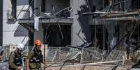 Policiais israelenses e especialistas em desarmamento de bombas são vistos trabalhando no local do impacto após um míssil supostamente lançado do Irã atingir a cidade de Bersheba, no sul de Israel, em 20 de junho de 2025. As autoridades iniciaram investigações após o incidente como parte de medidas de segurança mais amplas em meio às tensões regionais em curso.  Foto: Mostafa Alkharouf/Anadolu via Getty Images