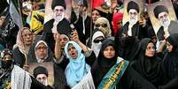 Mulheres seguram fotos do líder supremo, aiatolá Khamenei, durante manifestação de apoio no Irã  Foto: Getty Images / BBC News Brasil