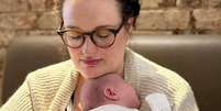 Charlie Beattie segura seu bebê de nove semanas nos braços depois de muitos anos de abortos espontâneos  Foto: Charlie Beattie / BBC News Brasil