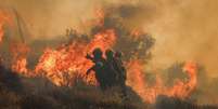 Bombeiros trabalham no combate ao ind&ecirc;ndio florestal na ilha de Creta, na Gr&eacute;cia.  Foto: AFP - COSTAS METAXAKIS / RFI